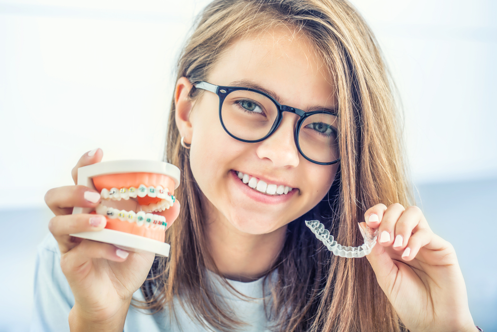 a teenager holding invisalign braces